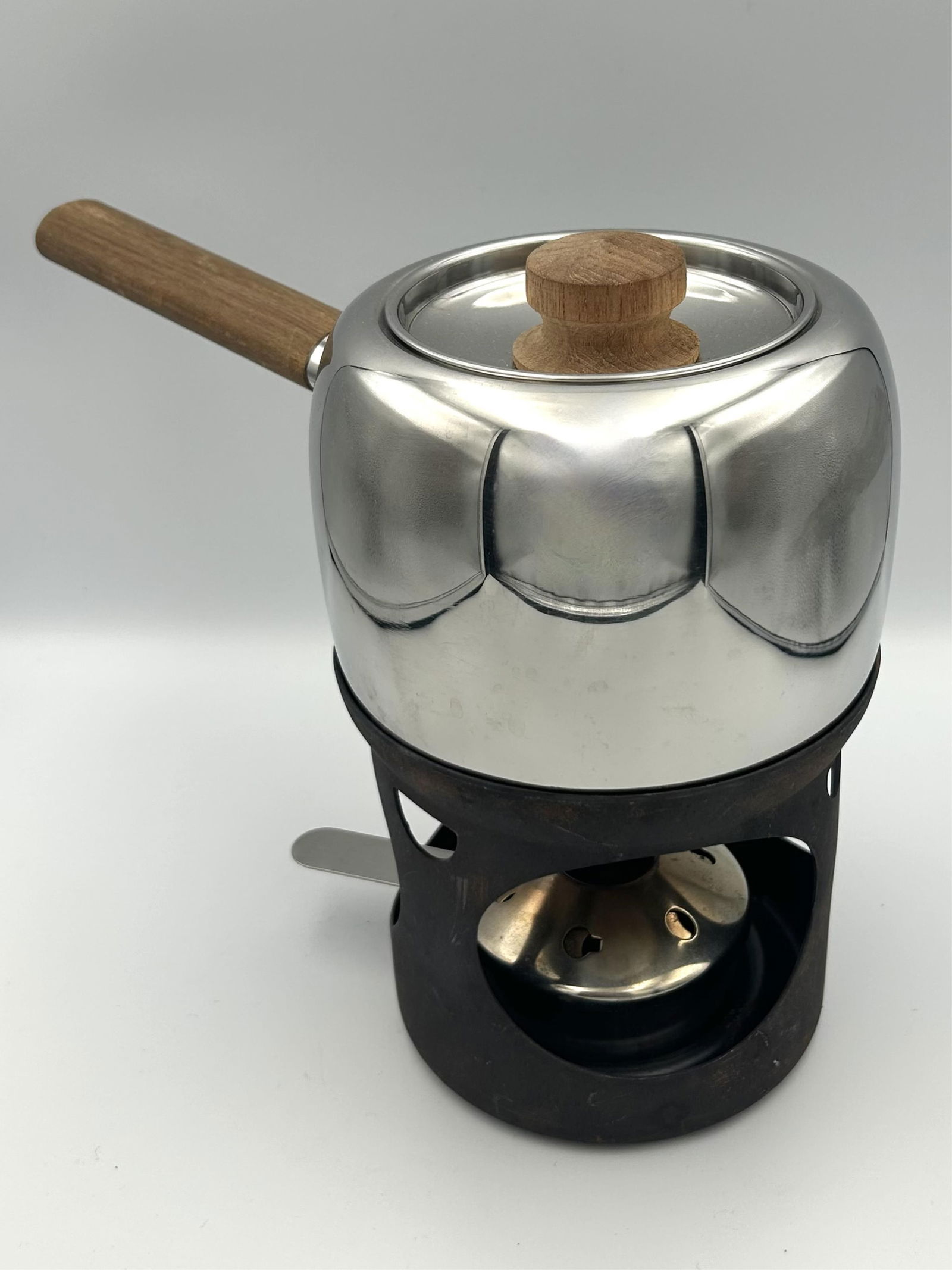 TIMO SARPANEVA (1926-2006) FOR OPA TEAK AND STEEL FONDUE POT Finland, 1970s Pot height 5". Width: TIMO SARPANEVA (1926-2006) FOR OPA TEAK AND STEEL FONDUE POTFinland, 1970sIncludes covered pot and burner.Pot height 5". Width 12". Burner height 5". Diameter 5.75".