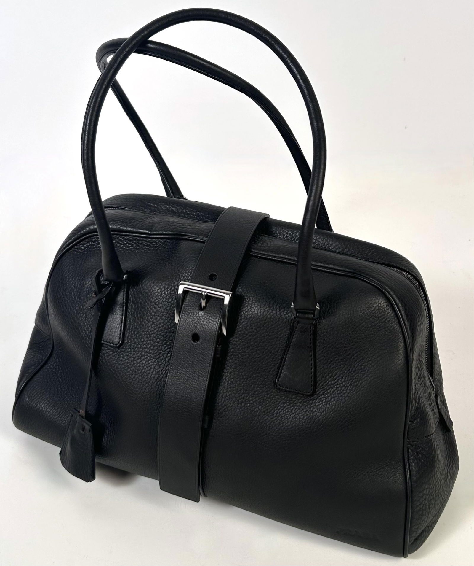 PRADA BROWN LEATHER DOUBLE-HANDLED BUCKLE BAG Contemporary Height 8.5". Width 14.5". Depth 5.5".: PRADA BROWN LEATHER DOUBLE-HANDLED BUCKLE BAGContemporaryZipper and buckle closure with lock and keys. Silver metal hardware. Includes original dust bag and authenticity card.Height 8.5". Width 14.5".