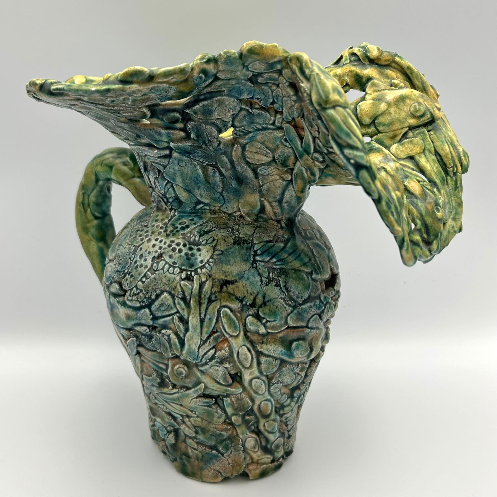KATE MALONE (England/France, 1959-), Sea life-themed pitcher with a colorful majolica-style glaze.,: KATE MALONEEngland/France, 1959-Sea life-themed pitcher with a colorful majolica-style glaze. Signed on underside "KM".Ceramic, height 9". Width at spout 10". Base diameter 3.5". Notes:Kate Malone wor
