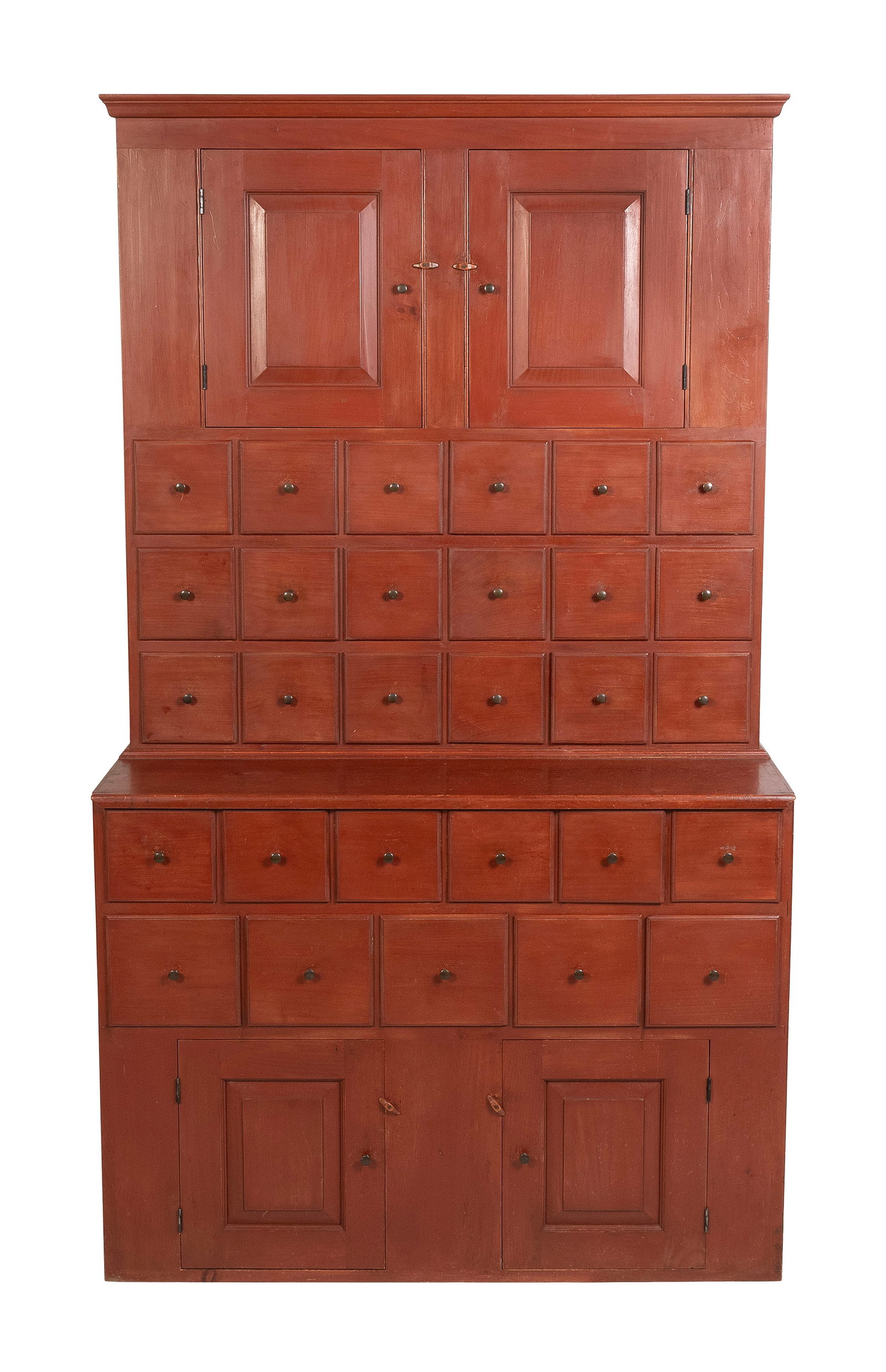 ELDRED WHEELER TWO-PART CUPBOARD Massachusetts, 20th Century Height 74". Width 42.5". Depth 18.5".: ELDRED WHEELER TWO-PART CUPBOARDMassachusetts, 20th CenturyPine under red paint. Upper case with two paneled doors over 18 small drawers. Interior fitted with a single shelf. Lower section with 11 dra
