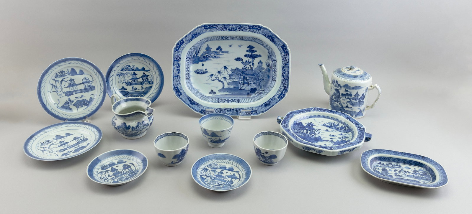 THIRTEEN PIECES OF CHINESE EXPORT BLUE AND WHITE CANTON PORCELAIN Mostly 19th Century: THIRTEEN PIECES OF CHINESE EXPORT BLUE AND WHITE CANTON PORCELAIN Mostly 19th Century 1) Octagonal deep platter. Length 14.5". 2) Teapot. 3) Cream pitcher. 4) Food warmer dish. 5-13) Assorted cups and