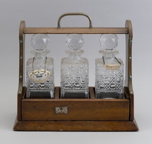 ENGLISH THREE-BOTTLE TANTALUS Early 20th Century Cabinet height 13". Width 13.5". Depth 5.5".