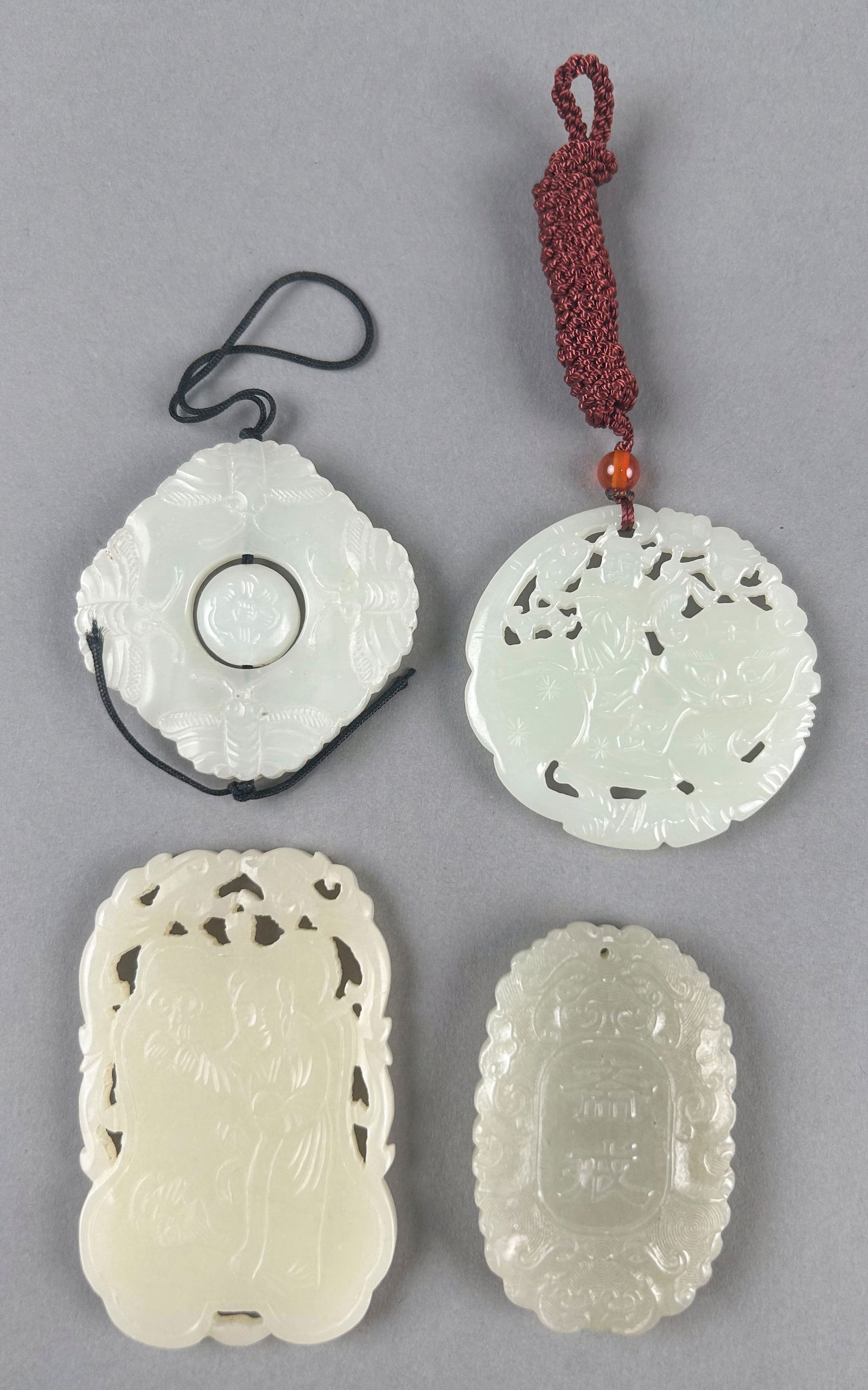 FOUR CHINESE WHITE JADE CARVED PENDANTS Lengths from 2" to 2.75". (1 of 6)