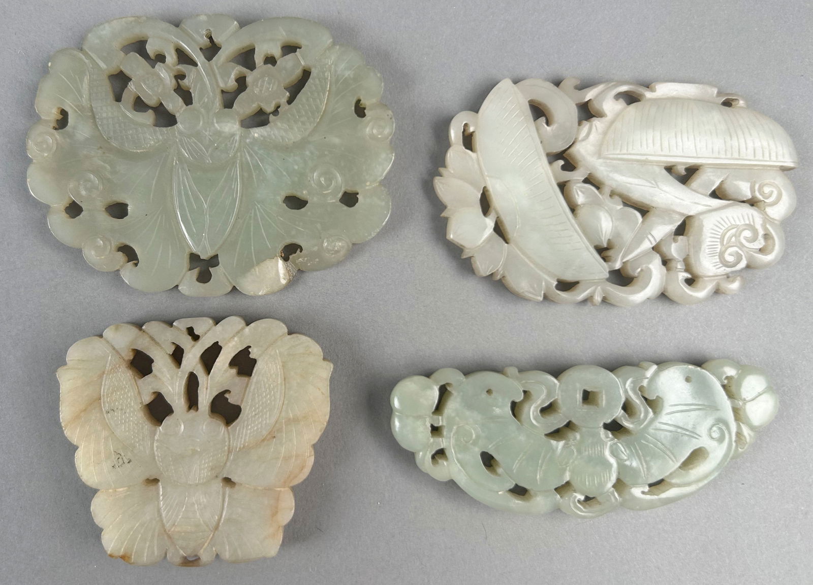 FOUR CHINESE OPENWORK CARVED GRAY JADE PLAQUES Lengths from 2" to 3.25". (1 of 2)