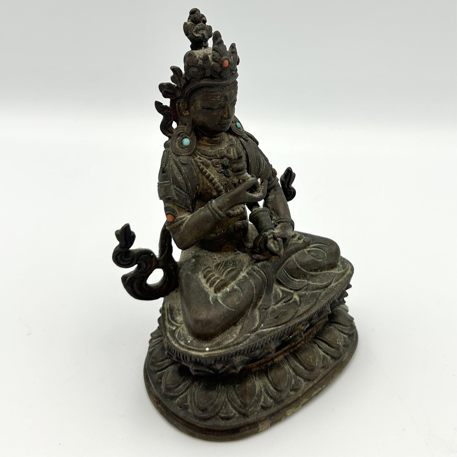 NEPALESE BRONZE FIGURE OF VAJRASATTVA 18th Century Height 5".: NEPALESE BRONZE FIGURE OF VAJRASATTVA 18th Century Holding a vajra and bell while seated on a lotus base. Small inlaid turquoise and coral cabochon ornamentation on headdress and robe. Incised lotus d