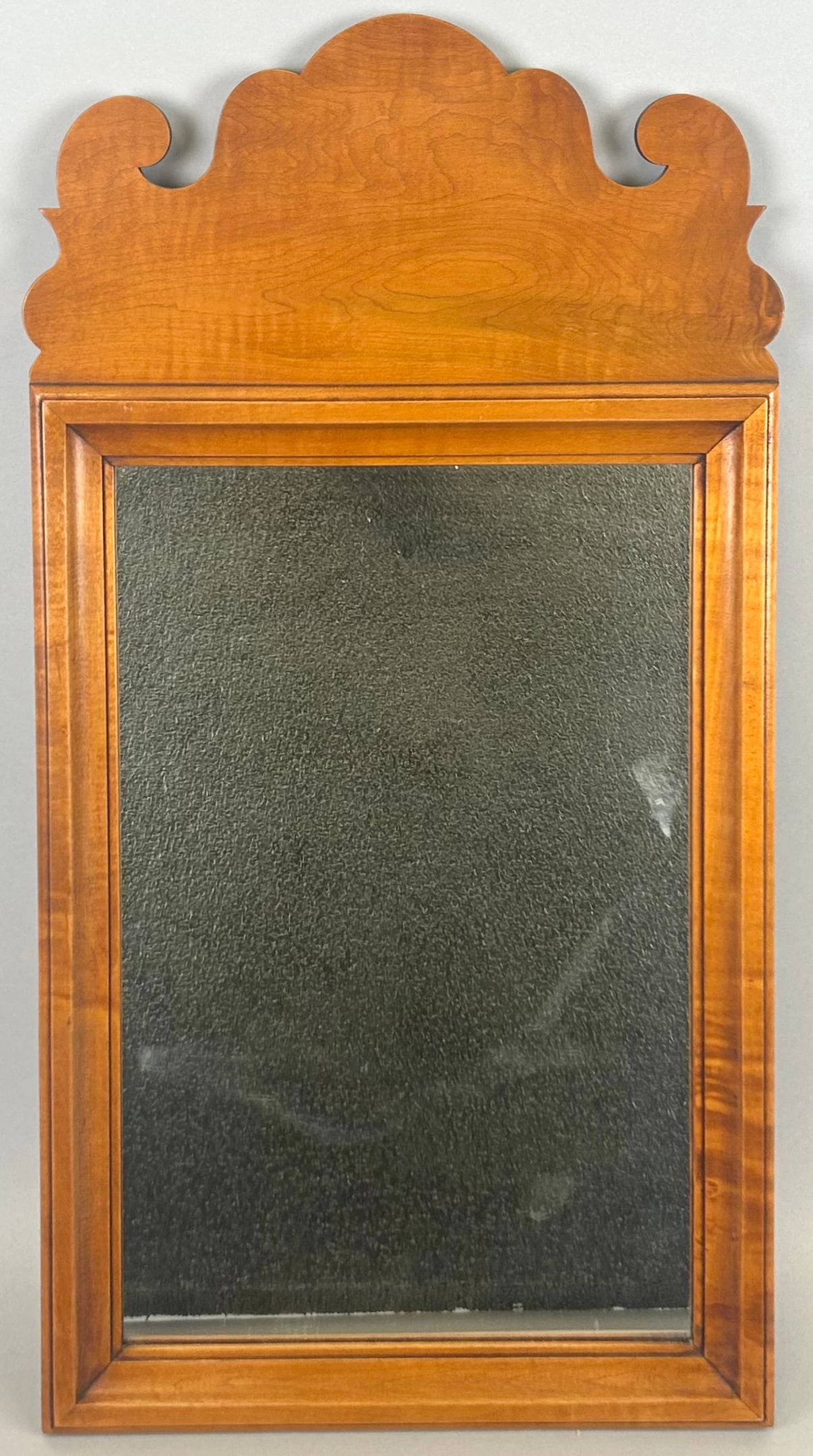 ELDRED WHEELER MIRROR 20th Century Height 24". Width 12.5".: ELDRED WHEELER MIRROR20th CenturyTiger maple frame with scrolled crest. Labeled on back.Height 24". Width 12.5".