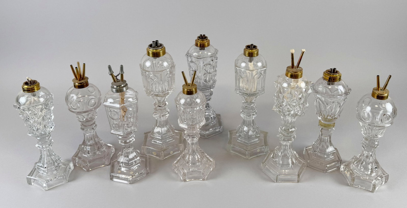 TEN FLINT PATTERN GLASS LAMPS Mid-19th Century Heights from 10.5" to 12.5".: TEN FLINT PATTERN GLASS LAMPS Mid-19th Century Each with whale oil burners. Heights from 10.5" to 12.5".