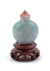 CARVED CELADON JADE SNUFF BOTTLE Early 20th Century Height 2". Includes wood stand.