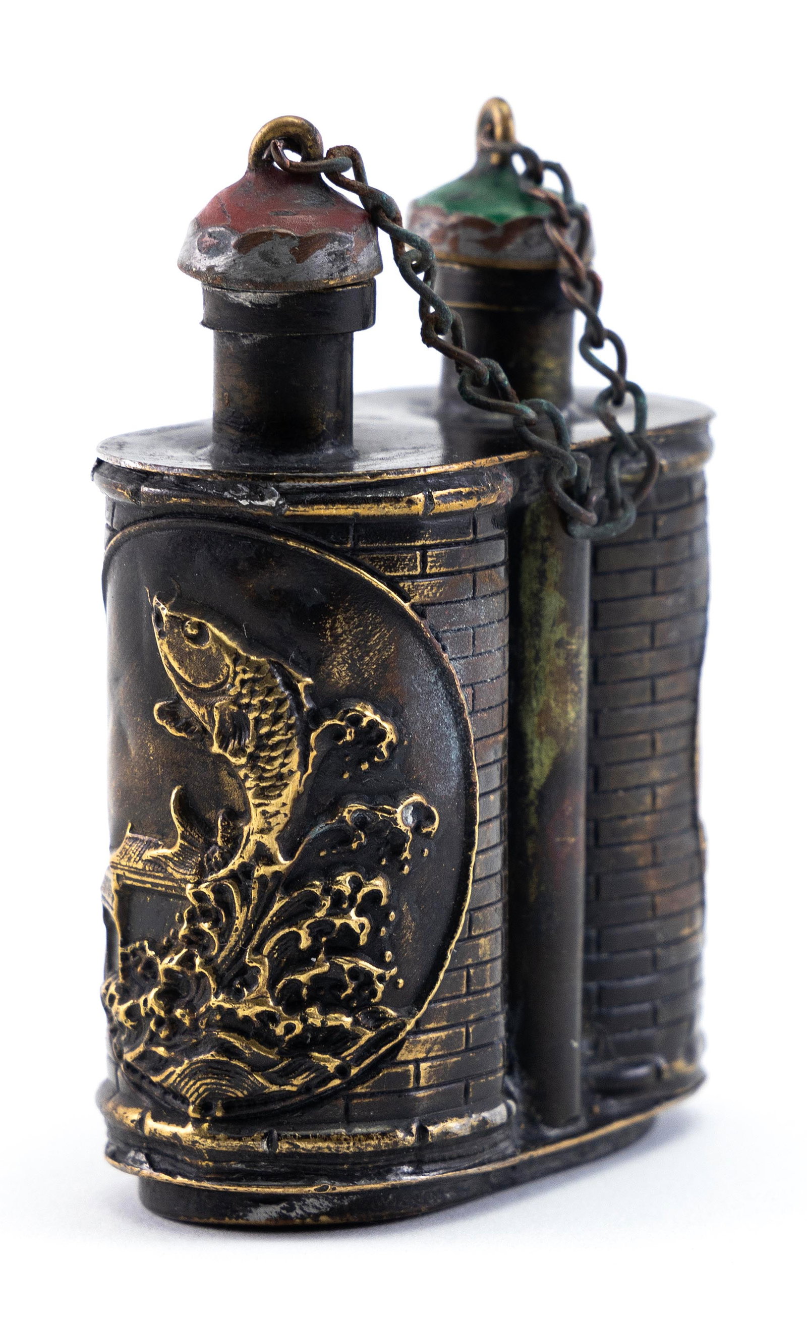 MIXED METAL DOUBLE SNUFF BOTTLE Late 19th Century Height 2.5". Length 2".: MIXED METAL DOUBLE SNUFF BOTTLE Late 19th Century Cylindrical form. Raised gilt metal medallions depicting carp jumping out of water against a brick-pattern ground. Red and green stone stoppers. Four-