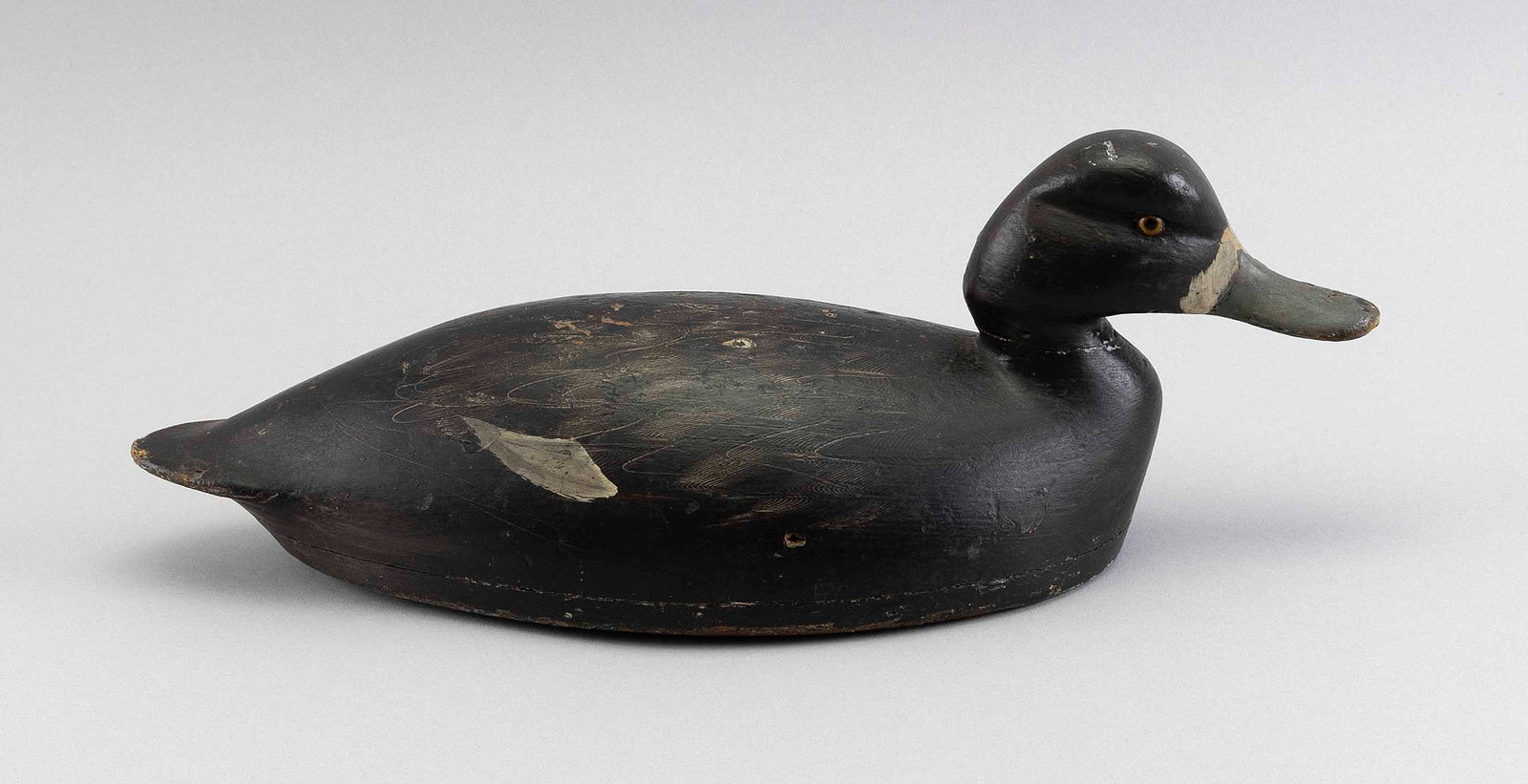 SAM DENNY BLUEBILL HEN DECOY Alexandria Bay, New York, 20th Century Length 16".: SAM DENNY BLUEBILL HEN DECOY Alexandria Bay, New York, 20th Century Glass eyes. Old gunning repaint. Old paper identification tag on underside. Length 16". Provenance: An Upstate New York Collection.