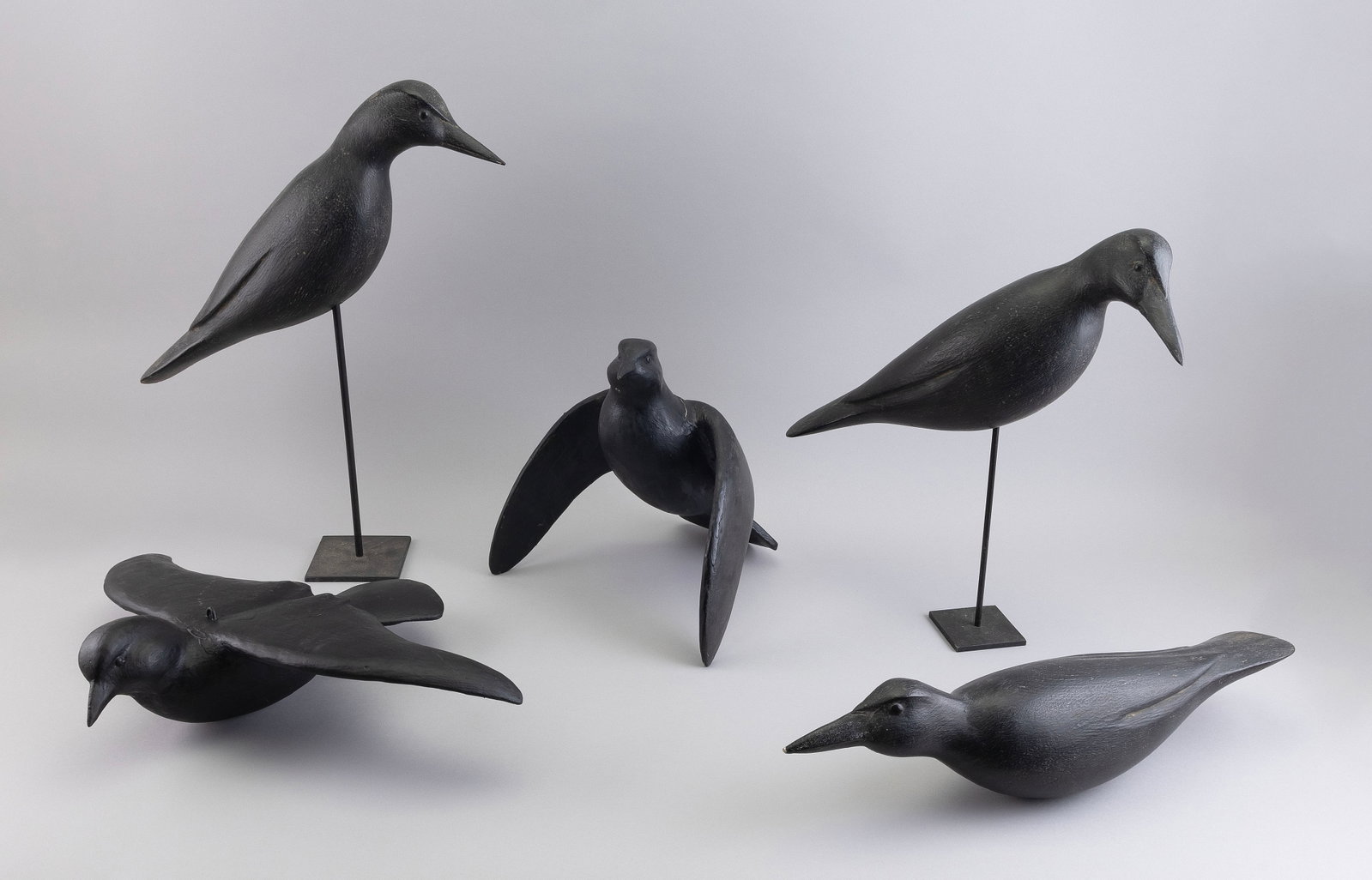 GROUP OF FIVE DECORATIVE CROWS 20th Century Lengths from 14" to 21".: GROUP OF FIVE DECORATIVE CROWS 20th Century All are carved wood. Makers unknown, although three bear a set of initials (see photo). The other two in flying form. Lengths from 14" to 21". Provenance: P