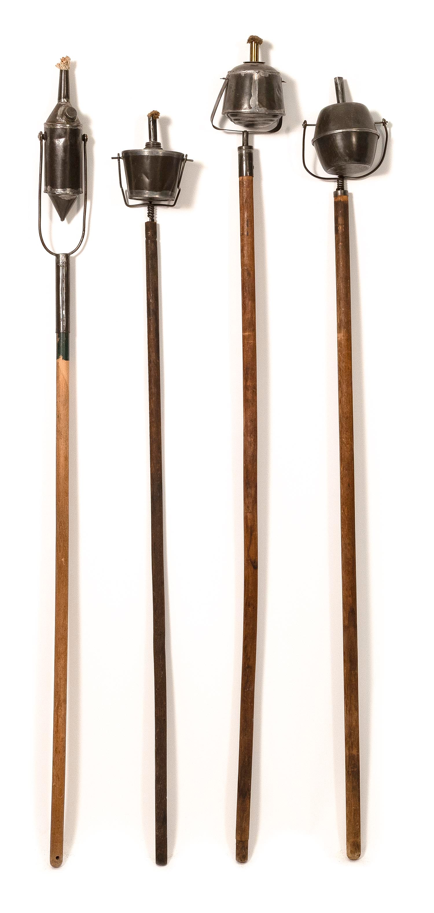 FOUR TIN PARADE TORCHES ON POLES Late 19th/Early 20th Century Heights from 51" to 56".: FOUR TIN PARADE TORCHES ON POLES Late 19th/Early 20th Century One pole is a later replacement. Heights from 51" to 56".
