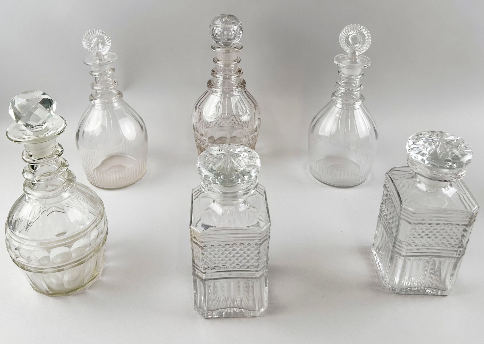 SIX CLEAR GLASS DECANTERS 19th/20th Century Heights from 8" to 11".: SIX CLEAR GLASS DECANTERS 19th/20th Century With stoppers. Heights from 8" to 11".