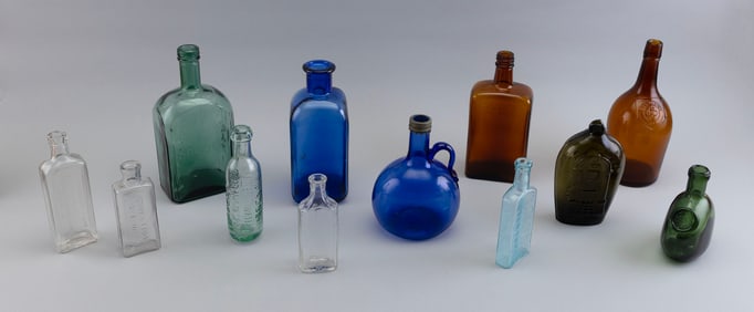 TWELVE ANTIQUE AND VINTAGE COLORED AND CLEAR GLASS BOTTLES 19th and 20th Centuries Heights from 5.5"
