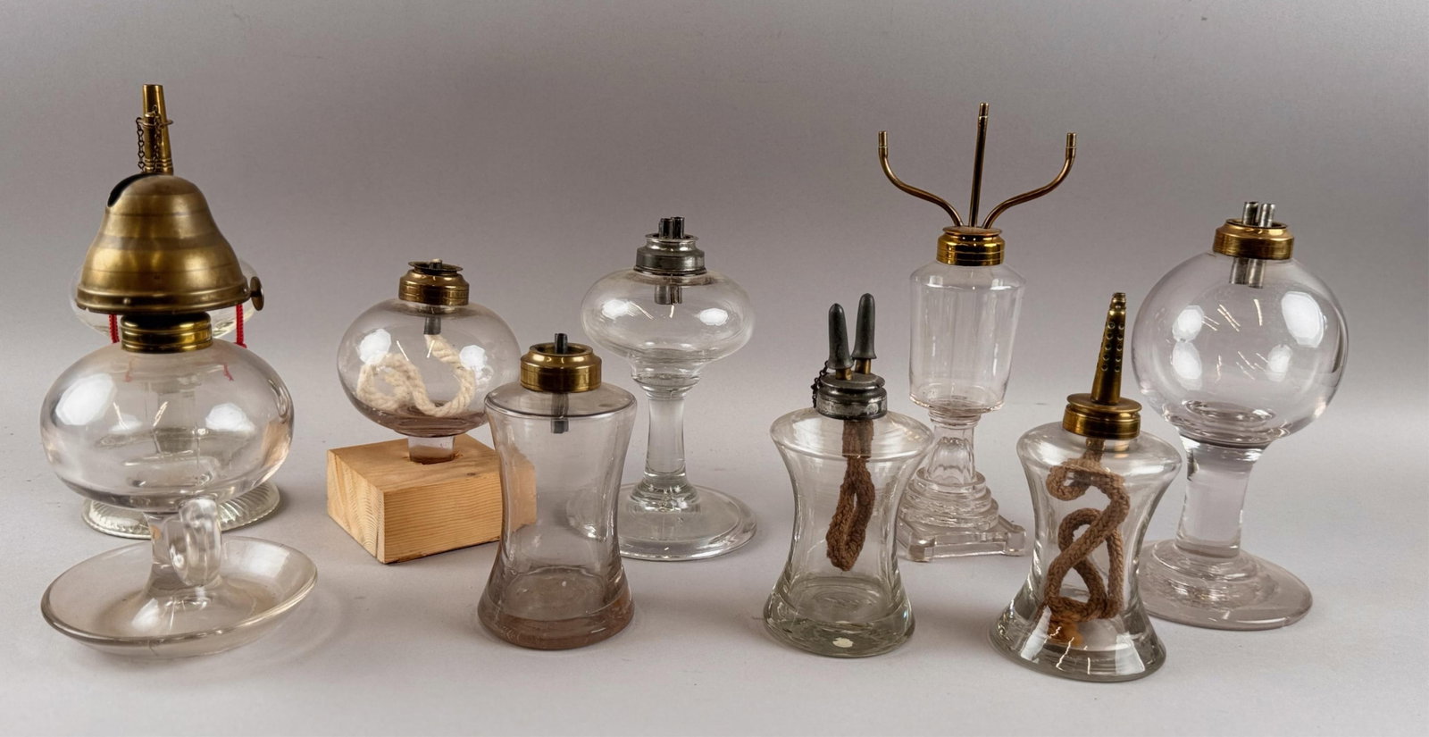 NINE CLEAR GLASS FLUID LAMPS, MOSTLY WHALE OIL 19th Century Heights from 5.5" to 9.25".: NINE CLEAR GLASS FLUID LAMPS, MOSTLY WHALE OIL 19th Century Heights from 5.5" to 9.25".