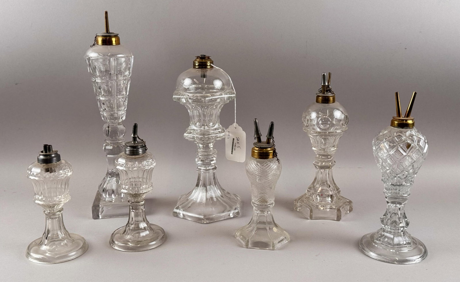 SEVEN FLINT PATTERN GLASS WHALE OIL LAMPS 19th Century Heights from 6.75" to 14".: SEVEN FLINT PATTERN GLASS WHALE OIL LAMPS 19th Century Varied patterns. All with original burners. Heights from 6.75" to 14".