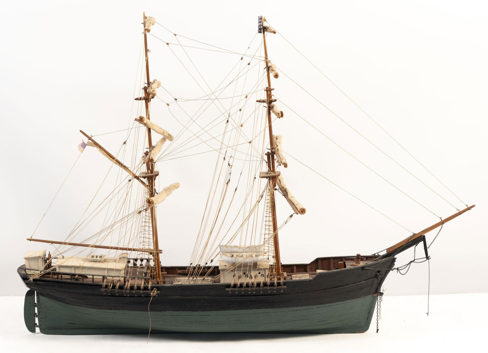 MODEL OF A TWO-MASTED AMERICAN SHIP 20th Century Height 28". Length 41".: MODEL OF A TWO-MASTED AMERICAN SHIP20th CenturyHull painted green and black. Furled cotton sails.Height 28". Length 41".