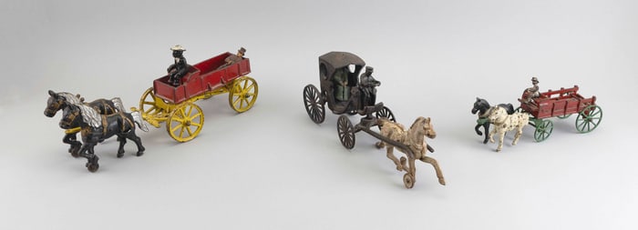 THREE CAST IRON HORSE-DRAWN TOYS Early 20th Century Lengths from 10" to 15".