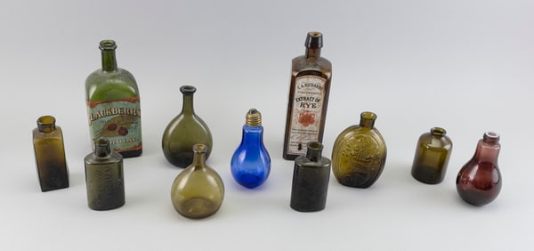 NINE AMBER GLASS BOTTLES AND TWO EARLY LIGHT BULBS 19th and Early 20th Century Heights from 4" to