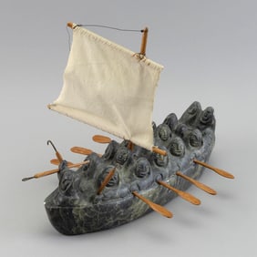 INUIT CARVED SOAPSTONE MIGRATION BOAT BY JONAS FABER Greenland, 1944- Height 10.25". Length 14".