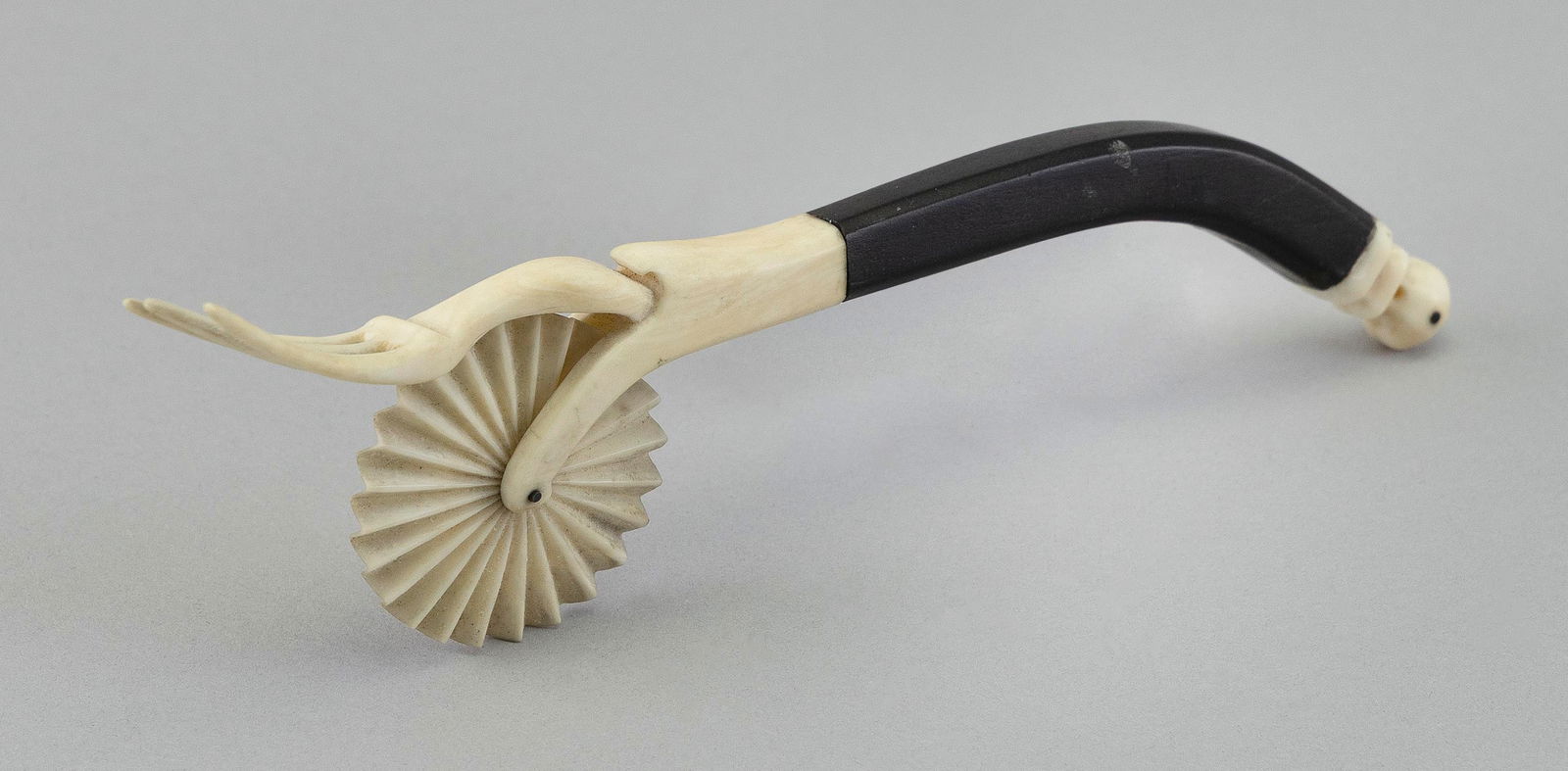 WHALE IVORY AND ISLAND WOOD PIE CRIMPER 19th Century Length 7.25".: WHALE IVORY AND ISLAND WOOD PIE CRIMPER19th CenturyDelicately carved. Whale ivory fluted wheel, fork and turned terminal. Dark island wood handle.Length 7.25".