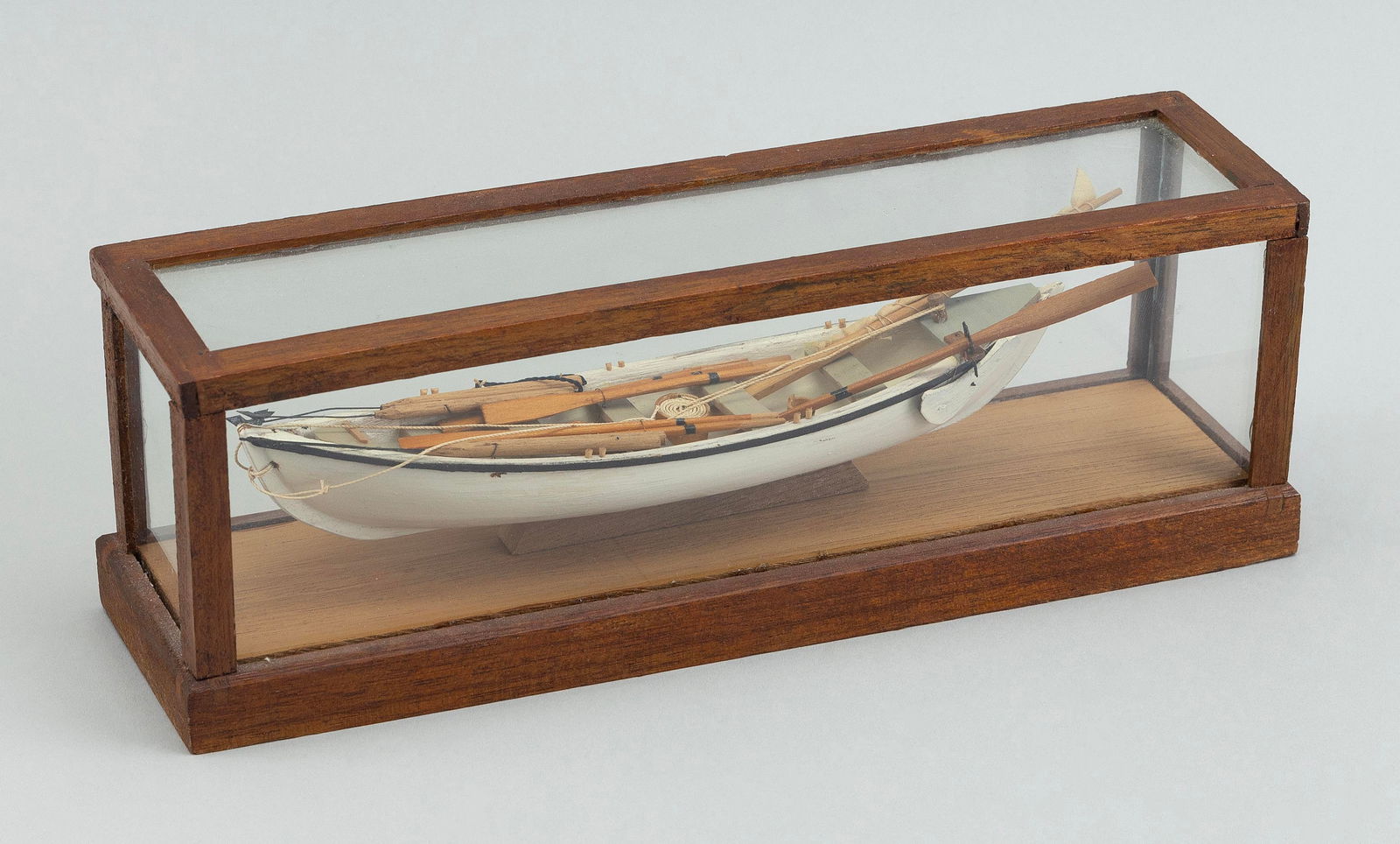 CASED MINIATURE MODEL OF A WHALEBOAT 20th Century Case height 3.5". Length 10.25". Width 3.75".: CASED MINIATURE MODEL OF A WHALEBOAT20th CenturyComplete with sails, implements and oars.Case height 3.5". Length 10.25". Width 3.75".