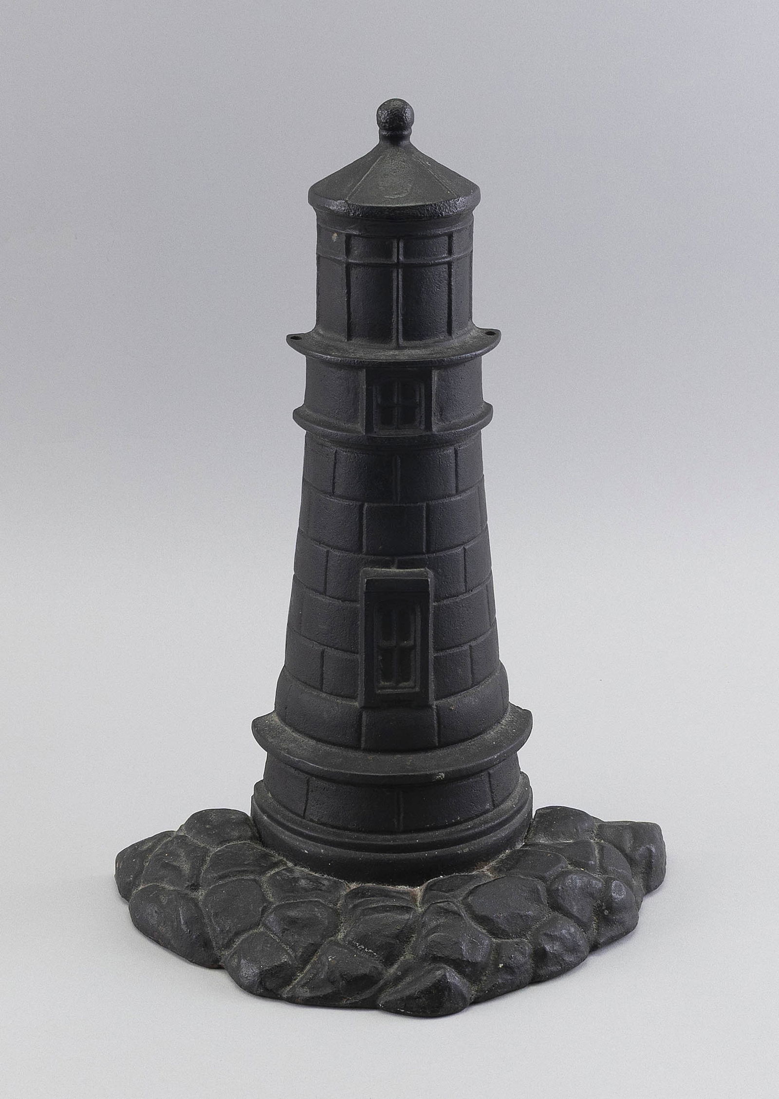 CAST IRON LIGHTHOUSE DOORSTOP Circa 1930 Height 14". Width 9.25".: CAST IRON LIGHTHOUSE DOORSTOPCirca 1930Under original black paint.Height 14". Width 9.25".