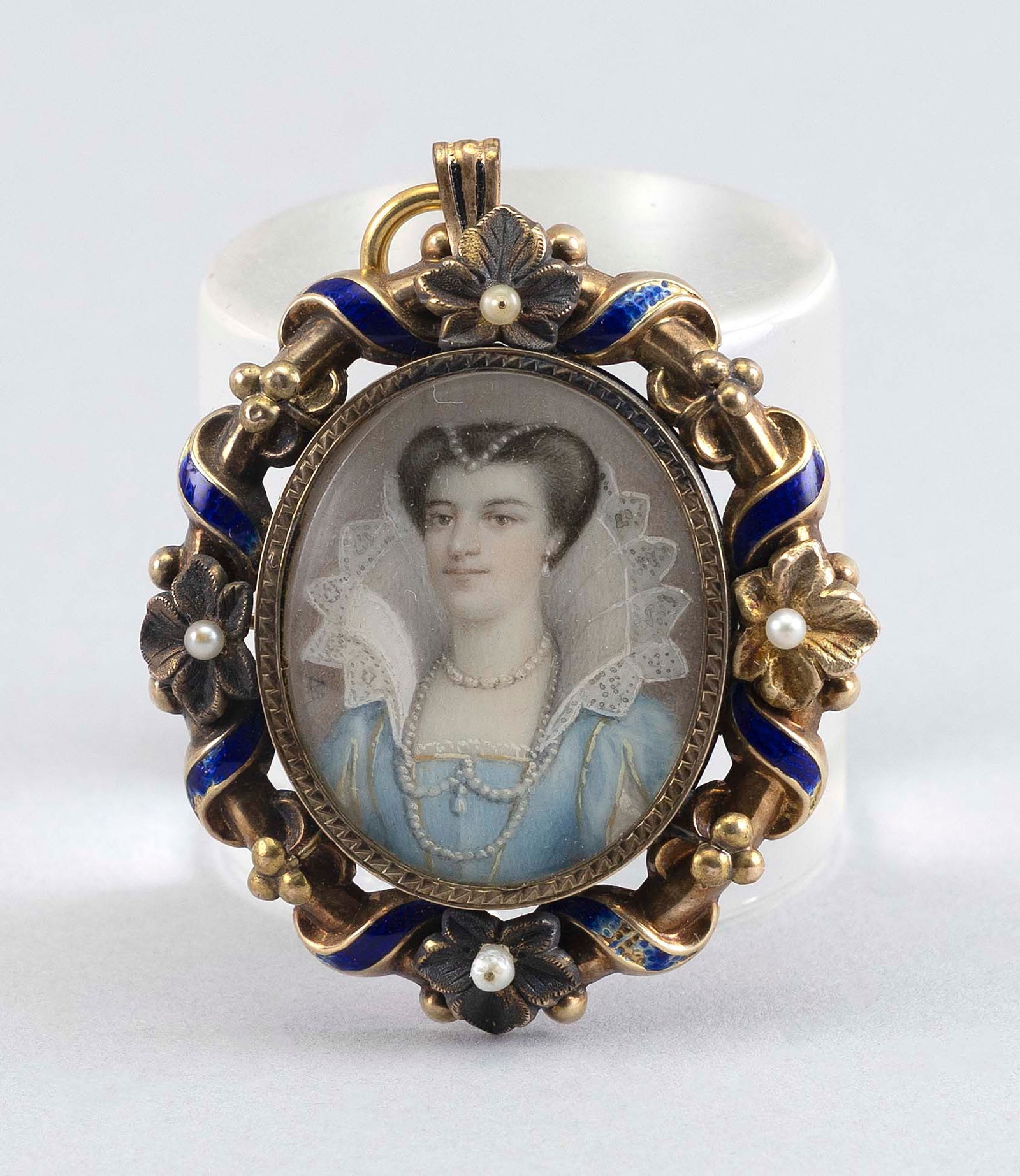 MINIATURE PORTRAIT OF A REGAL WOMAN SET WITHIN A 10KT GOLD BROOCH United Kingdom, Mid-19th Century