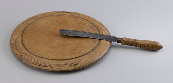 ENGLISH CARVED BREADBOARD AND KNIFE 19th Century Board diameter 12". Knife length 12".