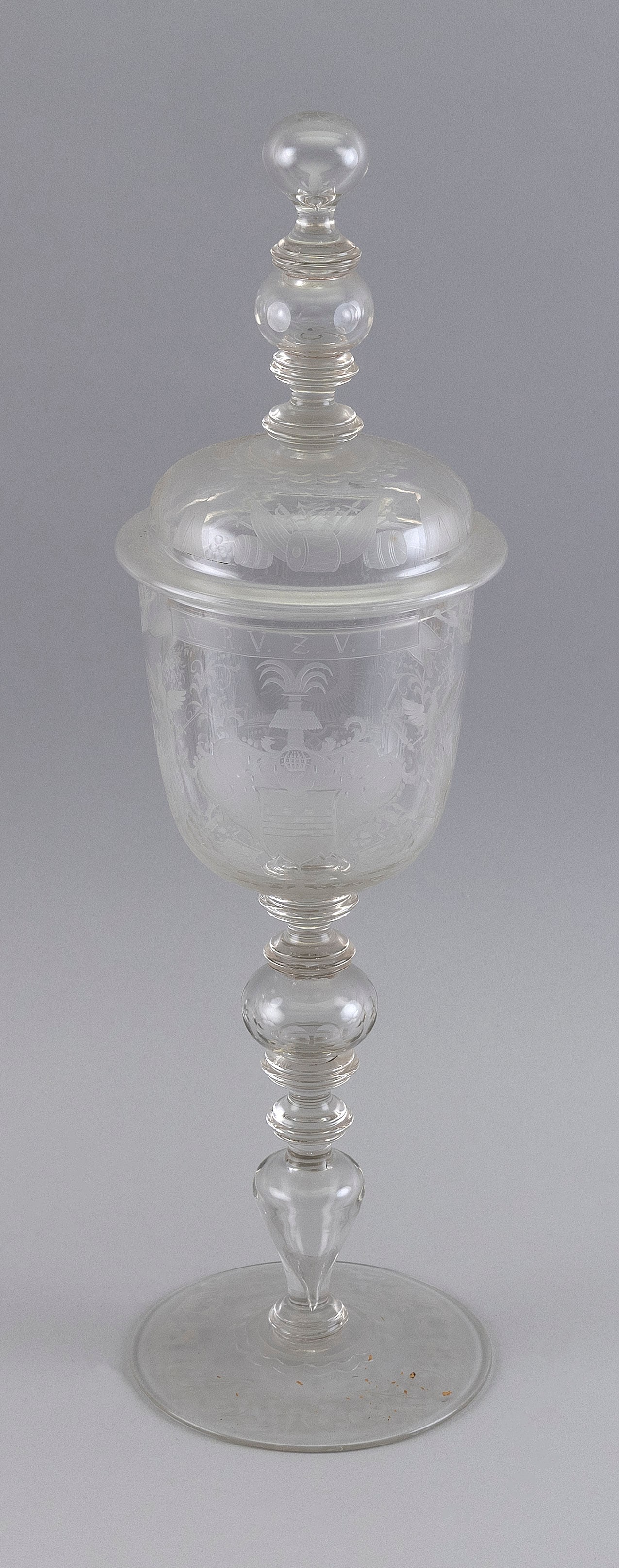 GERMAN ETCHED GLASS CEREMONIAL COVERED CUP Late 19th Century Height 19".: GERMAN ETCHED GLASS CEREMONIAL COVERED CUPLate 19th CenturyEtched with a German inscription and military-themed design of cannons, drums and flags.Height 19".