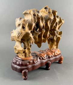 CHINESE SCHOLAR'S STONE ON A CARVED WOODEN STAND Stone height 11". Length 14". Width 4".
