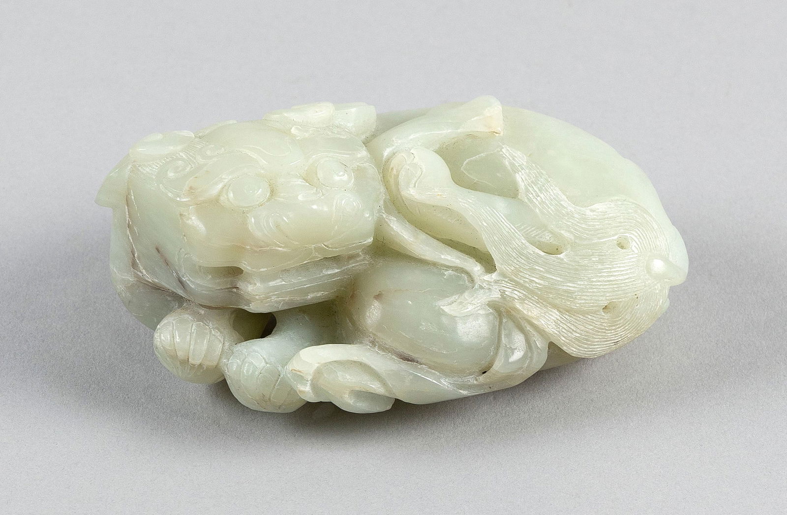 CHINESE CARVED PALE CELADON NEPHRITE JADE RECLINING LION 18th Century Length 4.5".: CHINESE CARVED PALE CELADON NEPHRITE JADE RECLINING LION18th CenturyLabel for Australian Antique Dealers Assocation on base.Length 4.5". Provenance:CP Lee Collection.