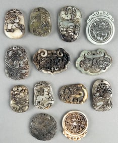 THIRTEEN CHINESE CARVED HARDSTONE PENDANTS Lengths from 0.75" to 2". With a fitted case.