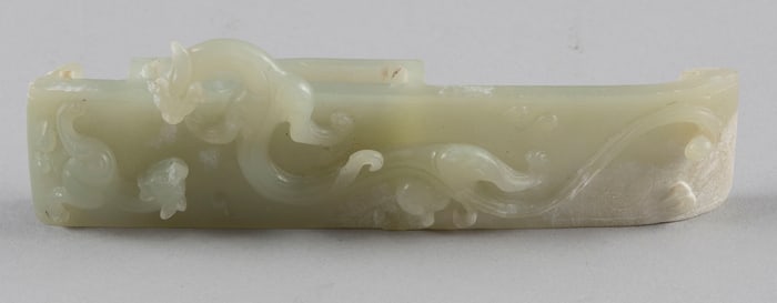CHINESE RELIEF-CARVED CELADON JADE SWORD SLIDE Mid-Qing Dynasty, 18th Century Length 6".