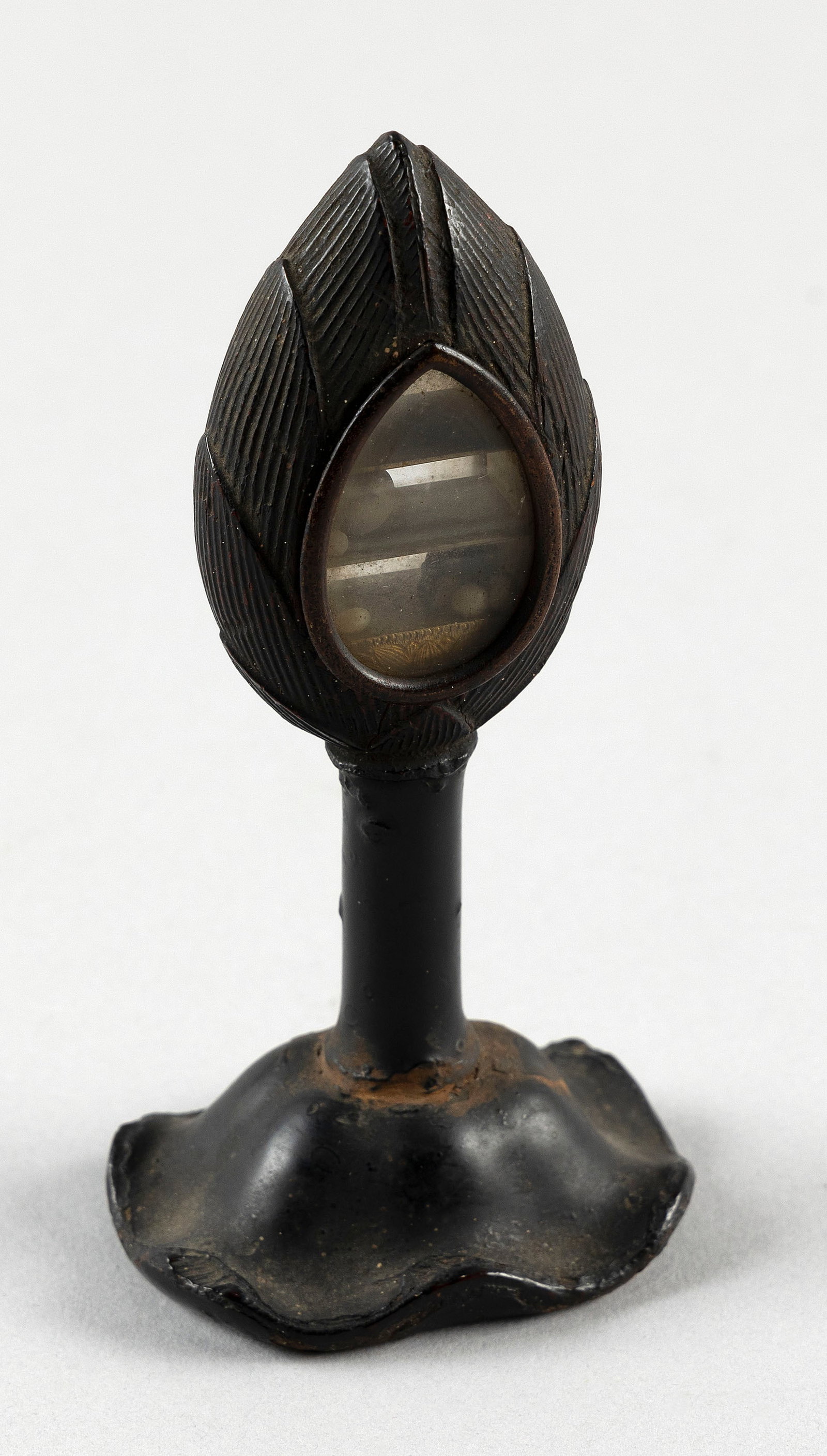 CHINESE BUDDHA RELIQUARY Height 5".: CHINESE BUDDHA RELIQUARYMetal flame-form reliquary on a lacquered lotus leaf-form base.Height 5".