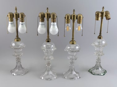 FOUR NEAR-MATCHING PRESSED CLEAR GLASS LAMPS 19th Century Total heights 20".