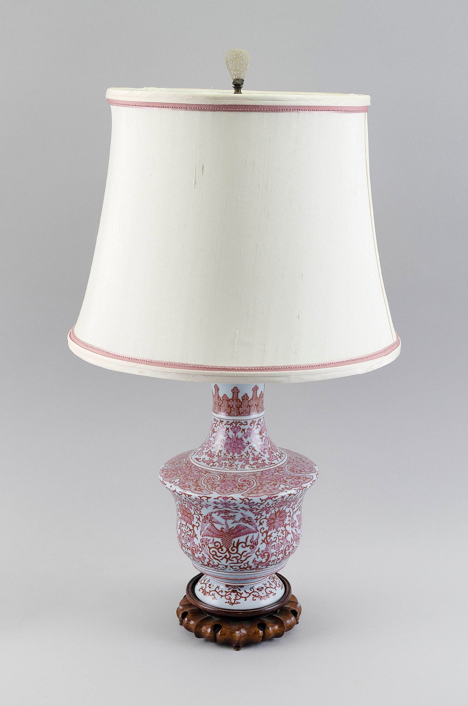 CHINESE FAMILLE ROSE PORCELAIN VASE 20th Century Total height 26.25".: CHINESE FAMILLE ROSE PORCELAIN VASE 20th Century Phoenix and lotus decoration with an unusual stippled lappet design at shoulder. Mounted as a table lamp and affixed to a carved wooden base. Carved se
