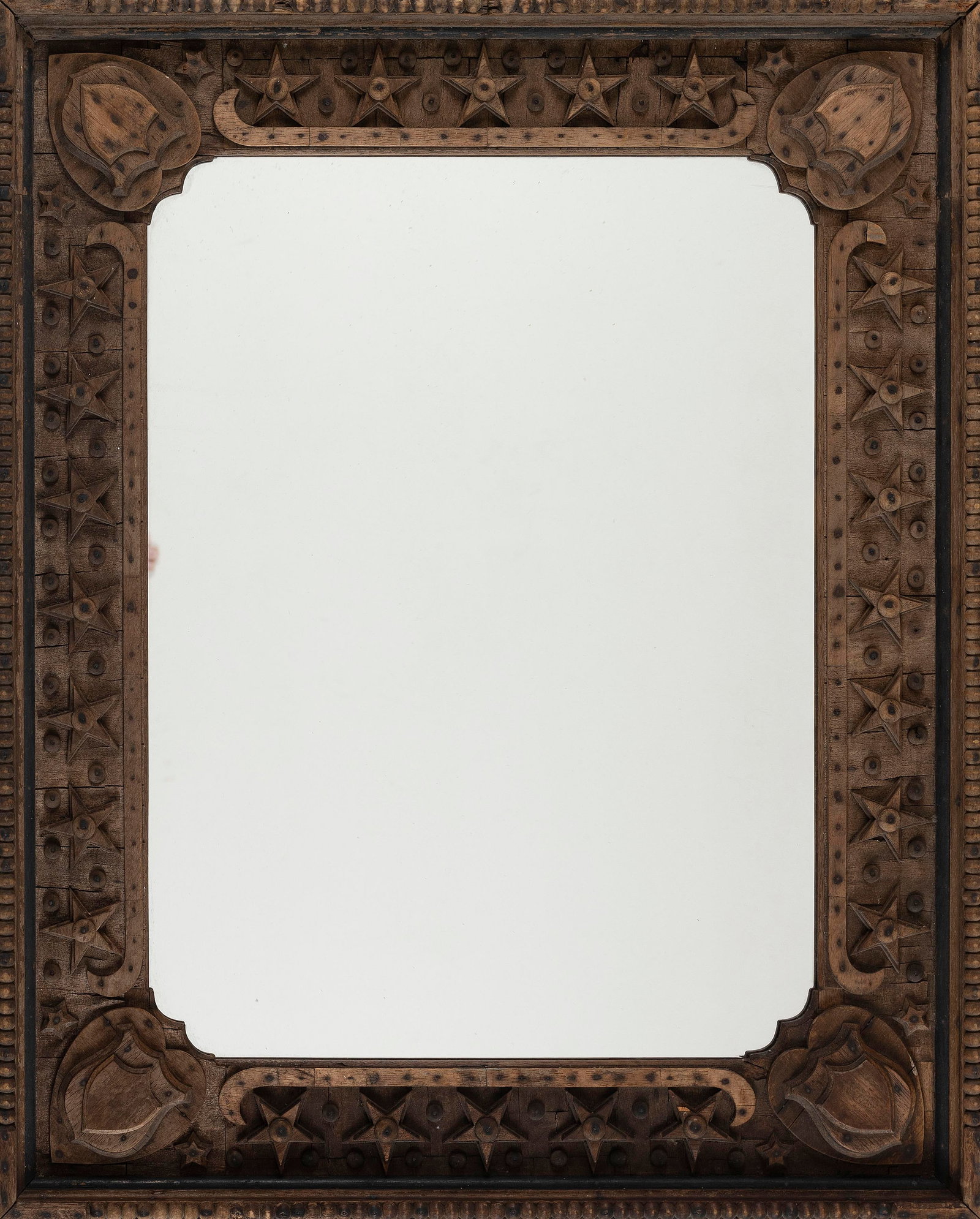 TRAMP ART FRAME WITH PATRIOTIC MOTIFS America, Circa 1890 32" x 26".: TRAMP ART FRAME WITH PATRIOTIC MOTIFS America, Circa 1890 Pine frame with decoration built up from thin layers of wood, probably reclaimed. Each corner with two different shield styles atop a heart. S