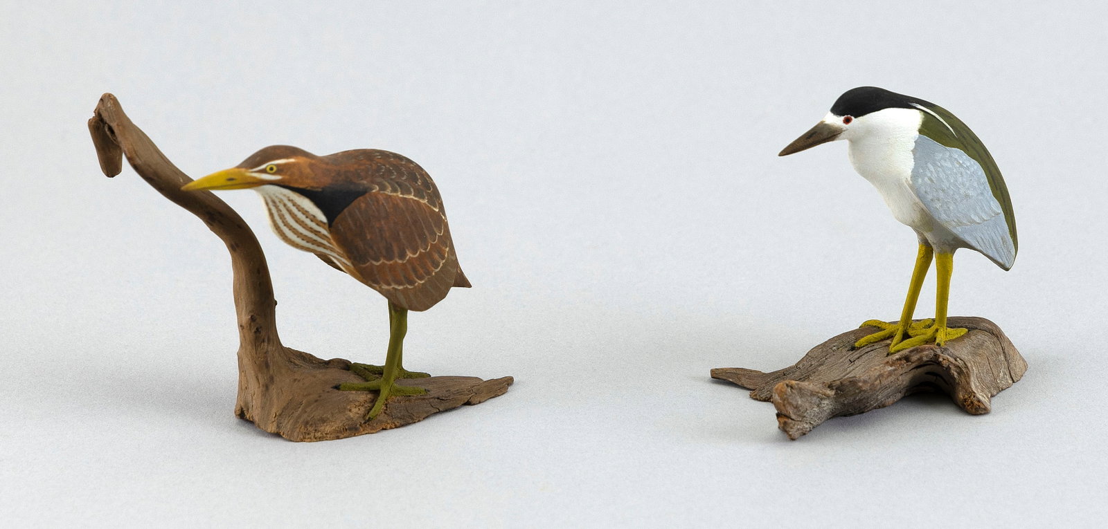 TWO HAROLD GIBBS MINIATURE HERONS Barrington, Rhode Island, 1886-1970 Heights 2.75".: TWO HAROLD GIBBS MINIATURE HERONS Barrington, Rhode Island, 1886-1970 Circa 1960. A bittern and a black-crowned night heron. Both mounted on driftwood bases. Signed "HG". Heights 2.75". Provenance: Th