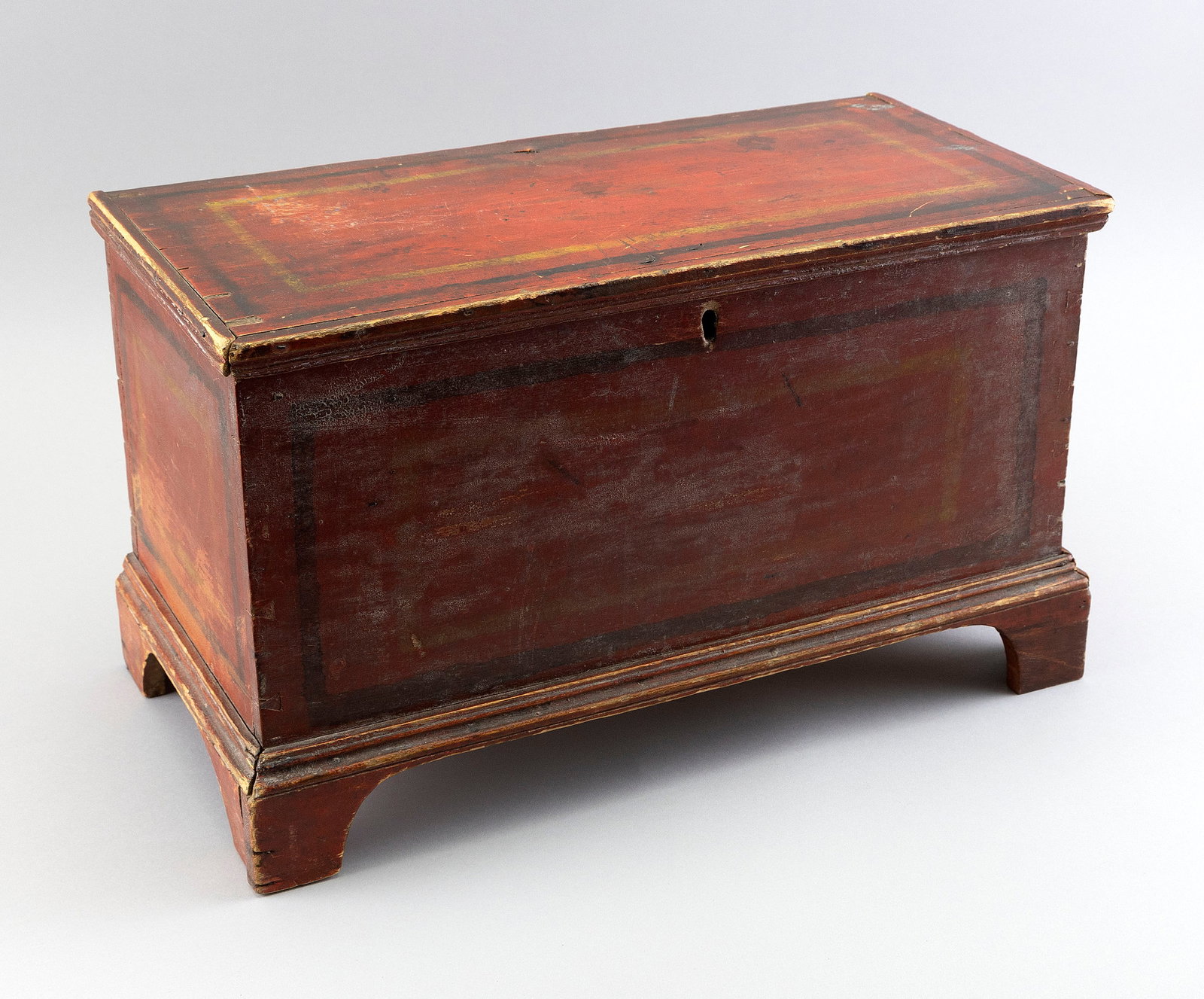 MINIATURE RED PAINTED PINE CHEST 19th Century Height 10.75". Width 19". Depth 10".: MINIATURE RED PAINTED PINE CHEST 19th Century With yellow and brown borders. Backboard with "Lois Kelly. Red Kill. Manfacterd[sic] by Wm Bollard" in green paint. Dovetail construction. Hinged lid. Int