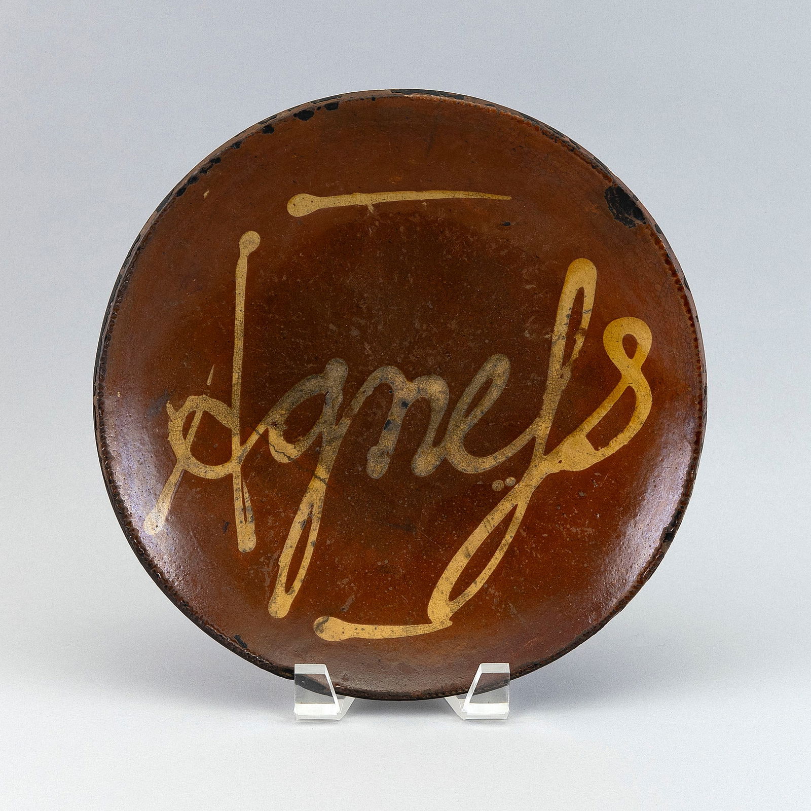 PENNSYLVANIA REDWARE PLATE WITH SLIP DECORATION 19th Century Diameter 10".: PENNSYLVANIA REDWARE PLATE WITH SLIP DECORATION19th Century"Agness[?]" in yellow.Diameter 10".