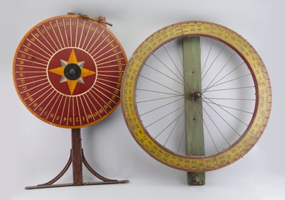 TWO WOODEN GAME WHEELS Early 20th Century Lengths 35" and 37".