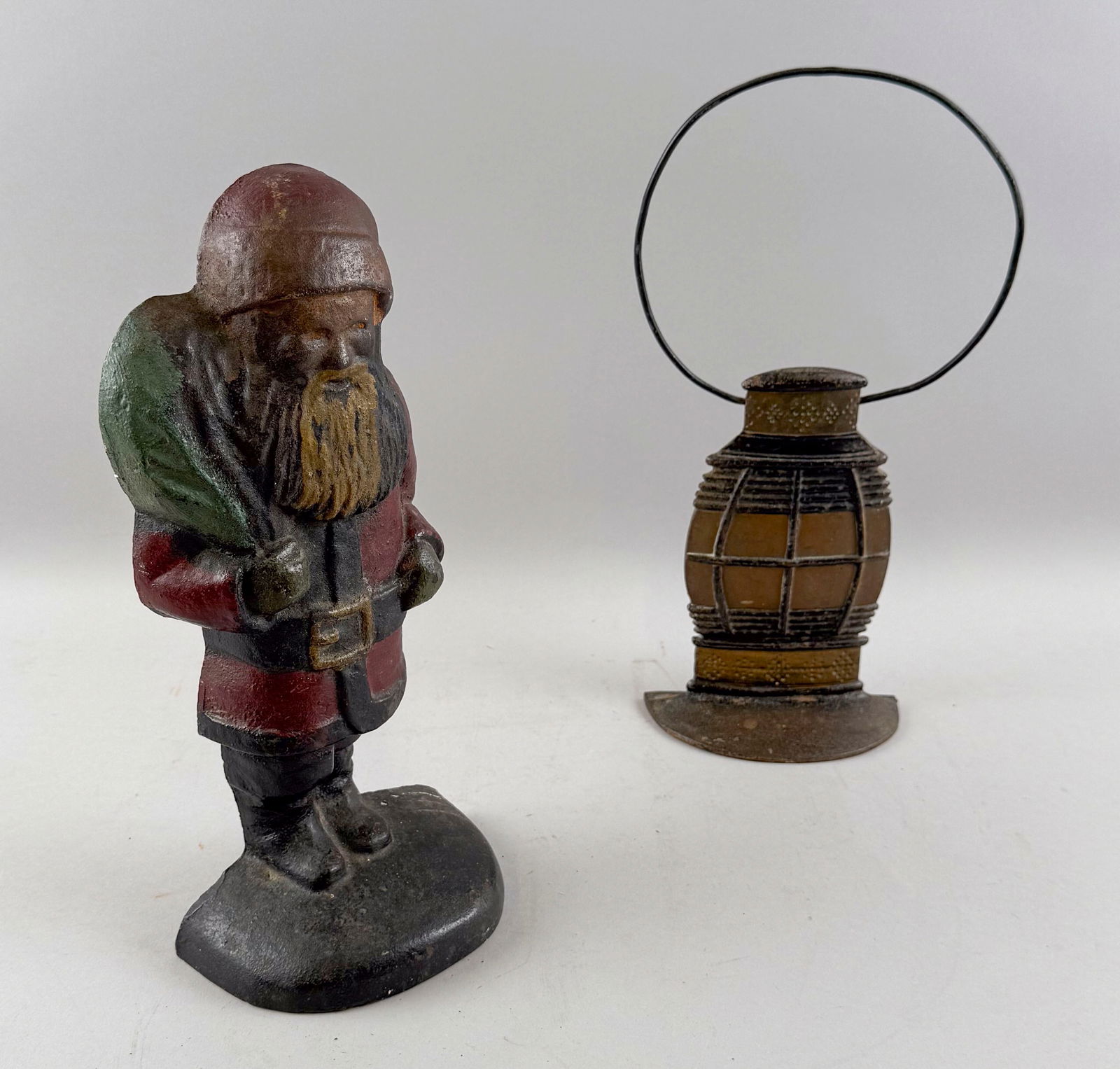 TWO RARE CAST IRON DOORSTOPS Early 20th Century Heights 13" and 13.5".: TWO RARE CAST IRON DOORSTOPSEarly 20th CenturyA Santa Claus and a marine lantern.Heights 13" and 13.5".