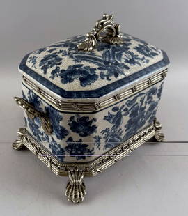 CHINESE BLUE AND WHITE PORCELAIN COVERED BOX WITH SILVERED METAL MOUNTS Late 20th Century Height: CHINESE BLUE AND WHITE PORCELAIN COVERED BOX WITH SILVERED METAL MOUNTSLate 20th CenturyPorcelain with birds and floral sprays against a crackled ground. Metal rim, handles, base and shell feet. Stamp