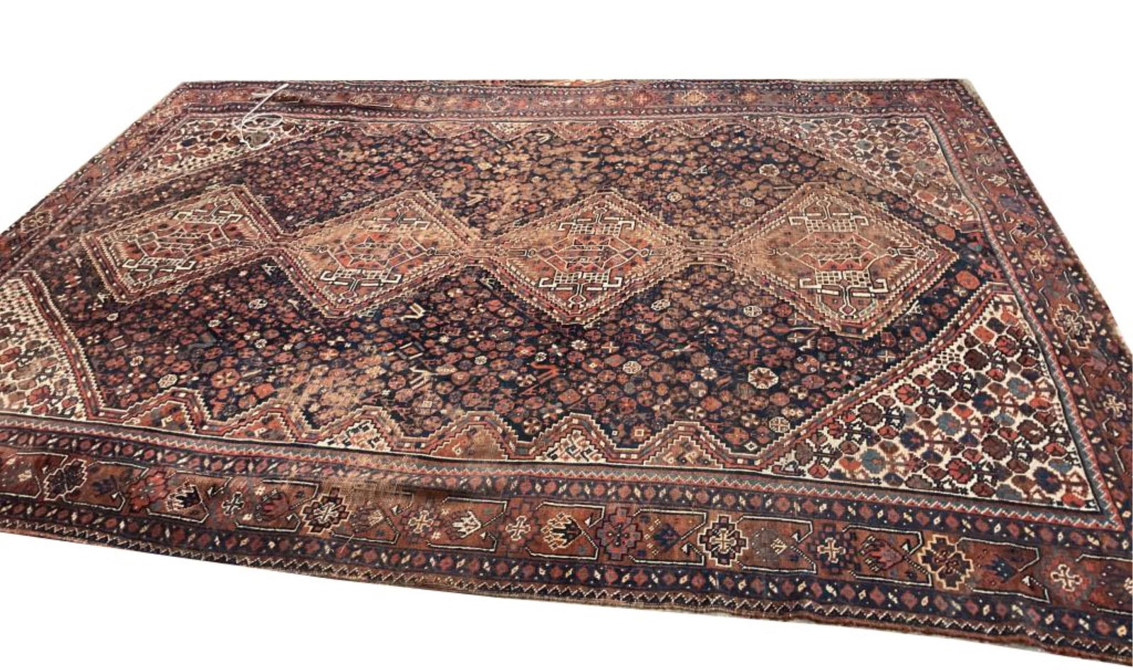 QASHQAI RUG: 7'8" X 9'1" First Quarter of the 20th Century: QASHQAI RUG: 7'8" X 9'1"First Quarter of the 20th CenturyTraditional diamond-shaped linked medallions are occupied by bold stylized elements in earth tones and bright ivory. Navy blue field is saturat