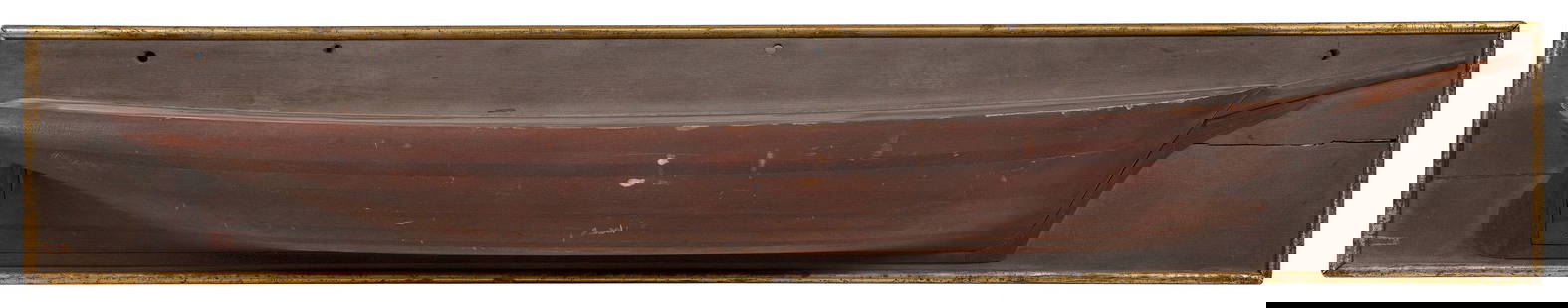 MOUNTED BUILDER'S HALF HULL MODEL OF A LARGE SAILING VESSEL 19th Century Backboard 11.75" x 62.5".: MOUNTED BUILDER'S HALF HULL MODEL OF A LARGE SAILING VESSEL19th CenturyBuilt up in 13 lifts. Applied sprit, carved prow, skeg and rudder. Backboard with gilt molded edge.Backboard 11.75" x 62.5".Prove