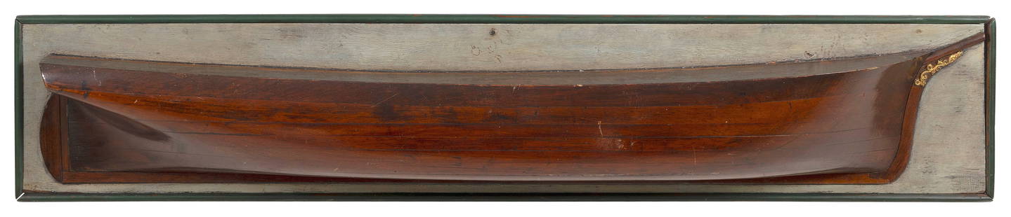 MOUNTED HALF HULL MODEL OF A SHIP 19th Century Backboard 11" x 56".: MOUNTED HALF HULL MODEL OF A SHIP19th CenturyBuilt up in seven lifts. Nicely carved and gilded trailboards.Backboard 11" x 56".