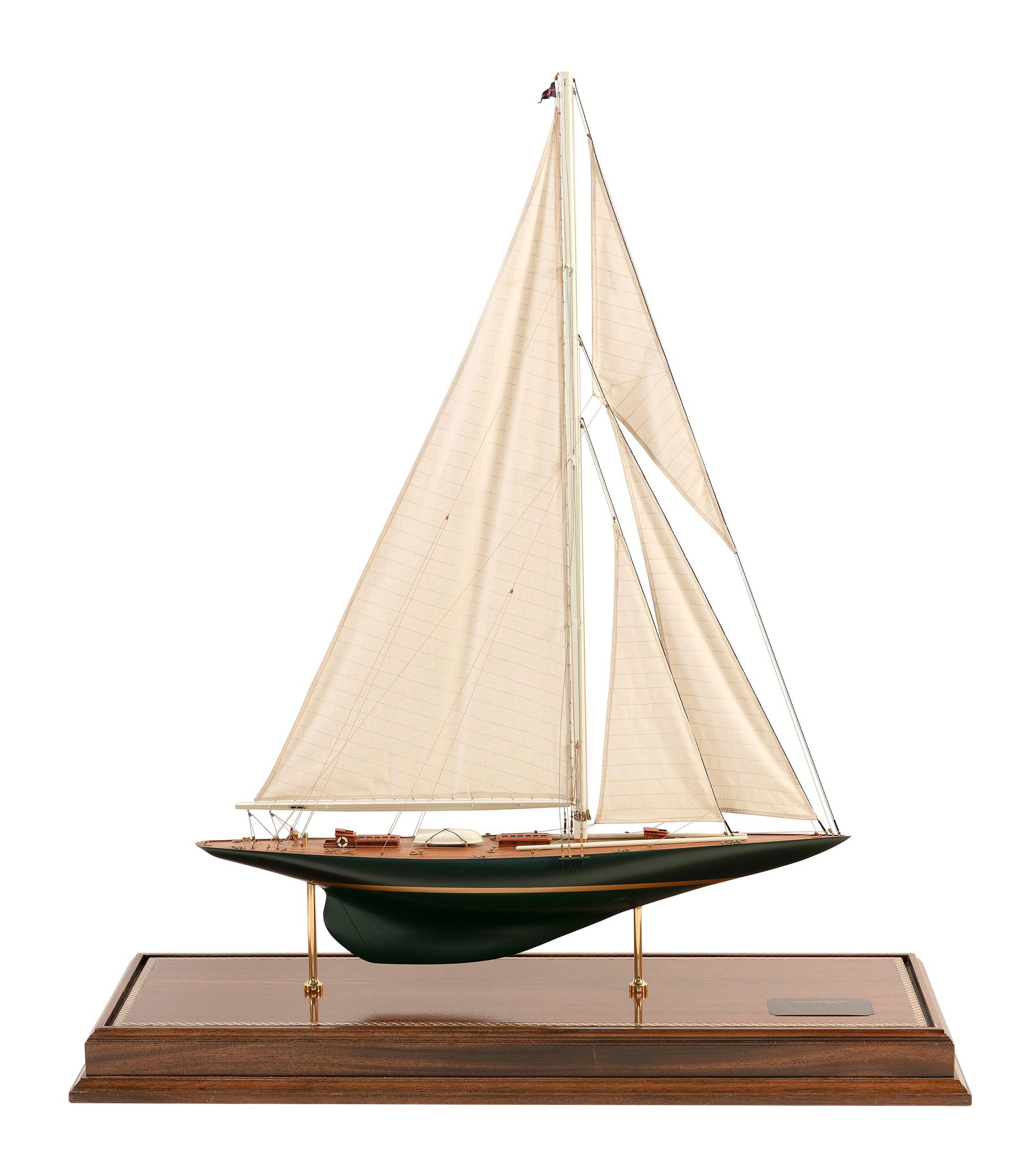 CASED MODEL OF THE AMERICA'S CUP YACHT "SHAMROCK V" 20th Century Case height 39". Length 33". Width: CASED MODEL OF THE AMERICA'S CUP YACHT "SHAMROCK V"20th CenturyOwned by Sir Thomas Lipton. Planked mahogany deck. Linen sails. Displayed on brass pedestals within a brass-trimmed glass case with woode