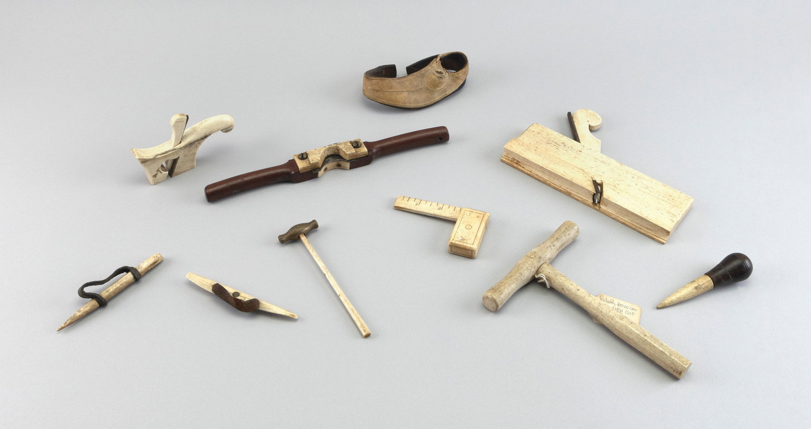 TEN WHALEBONE AND WOOD TOOLS 19th Century Lengths from 4.5" to 8".: TEN WHALEBONE AND WOOD TOOLS 19th Century A square, a spoke shave, two planes, two hammers, a sailor's palm and several whalebone needles. Lengths from 4.5" to 8".