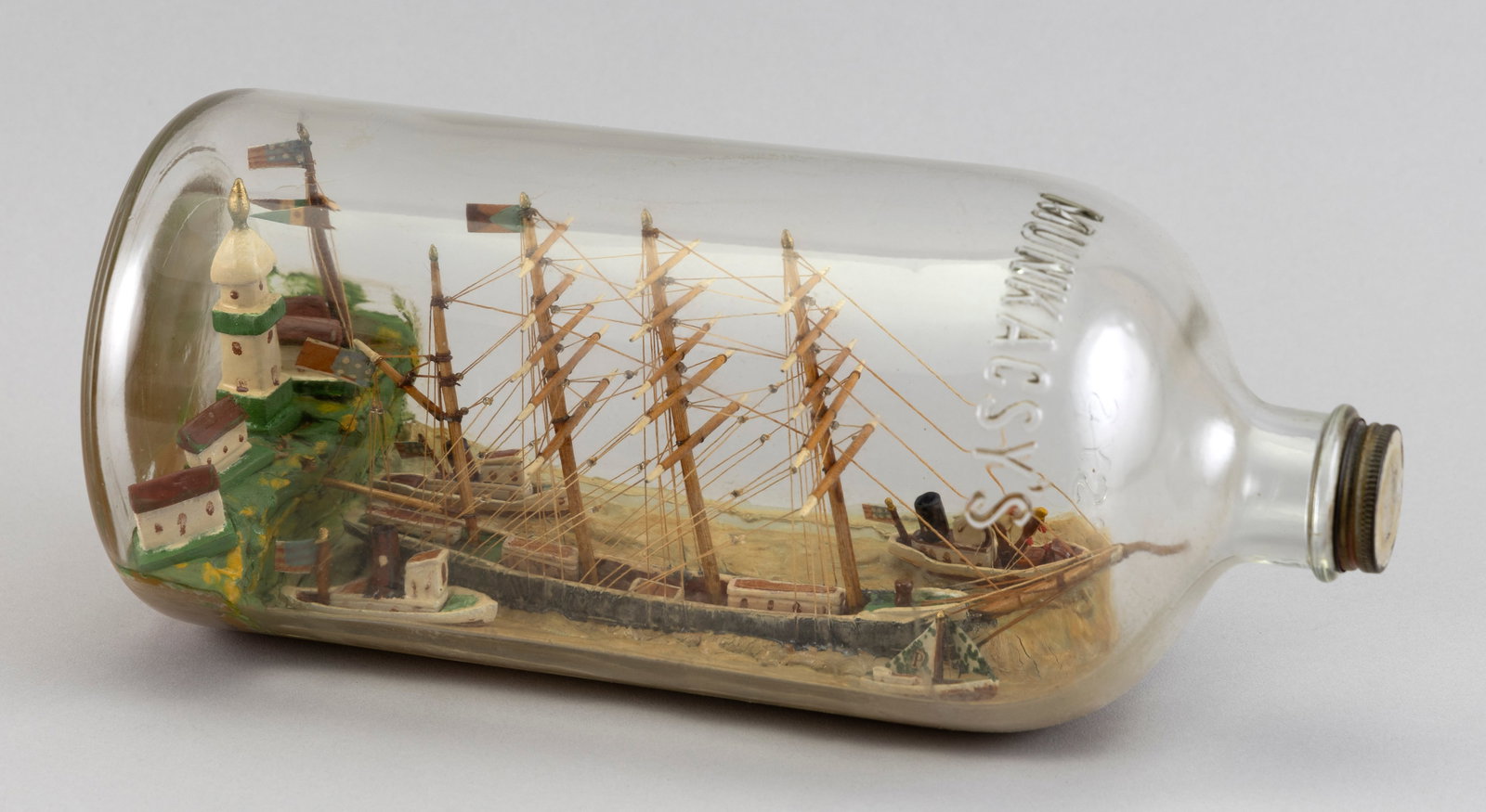 SHIP IN A BOTTLE 20th Century Height 6.5". Length 13".: SHIP IN A BOTTLE 20th Century Four-masted vessel shown in port, surrounded by other vessels. Height 6.5". Length 13".